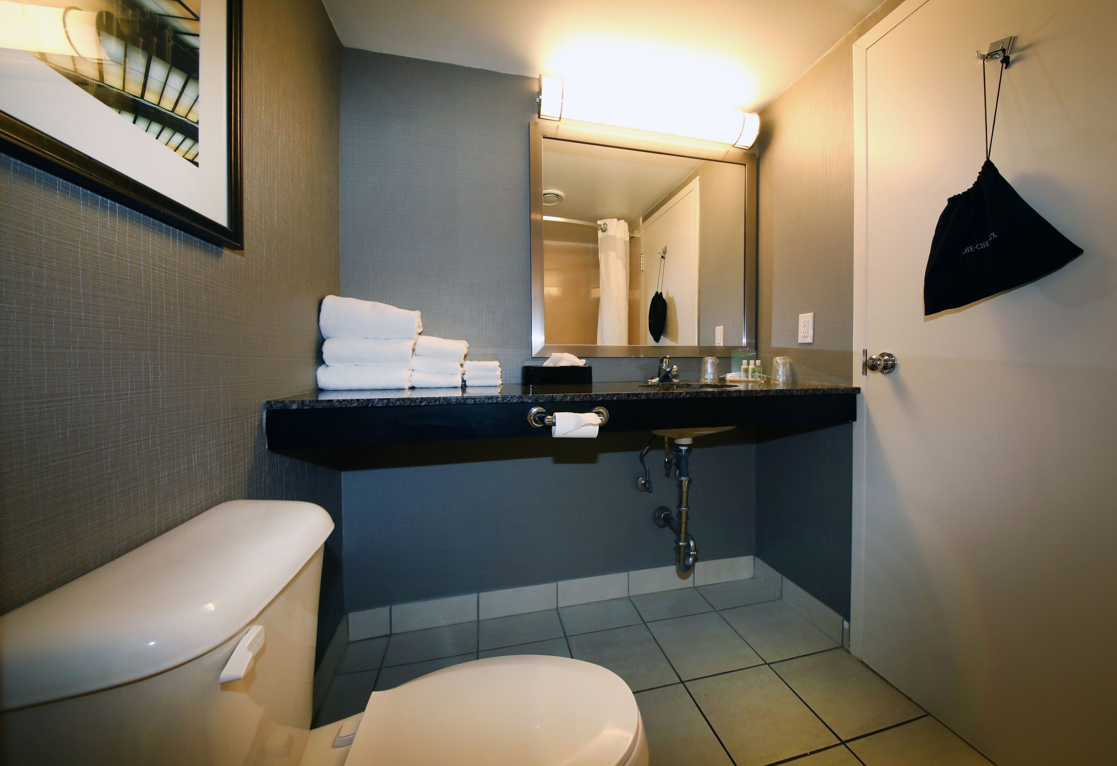 Un baño moderno con inodoro, lavamanos y espejo.