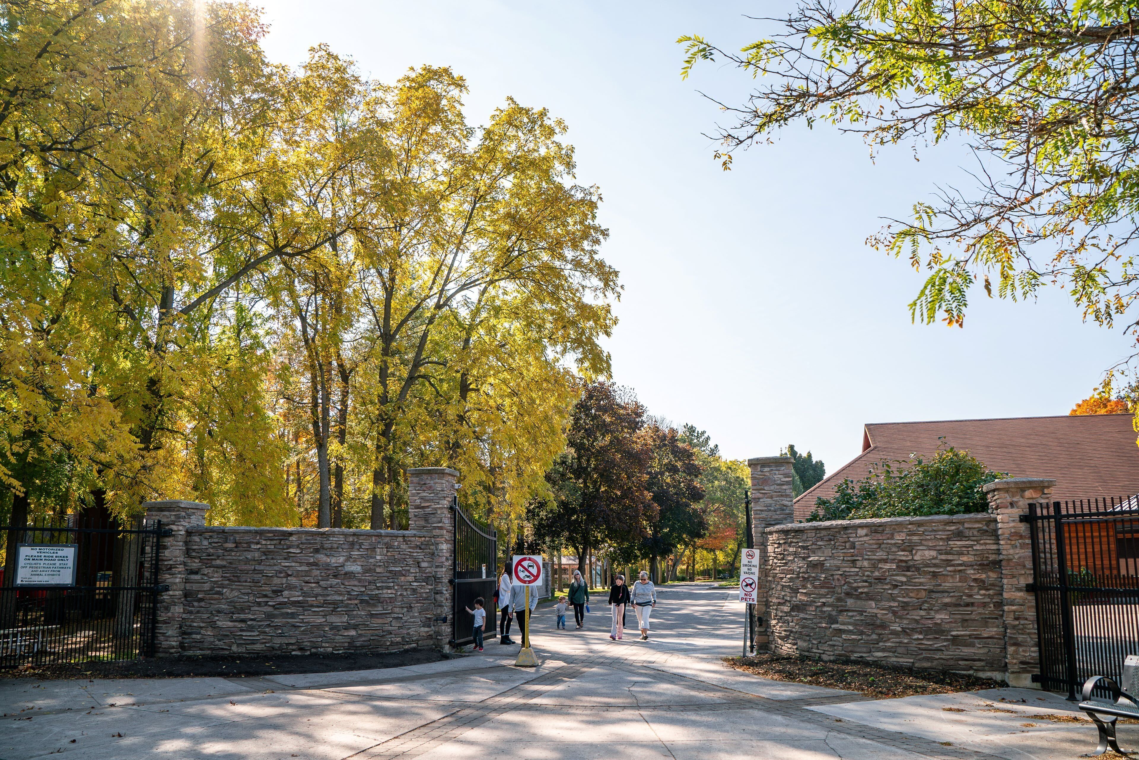 A gated entrance with stone walls and a clear sky.