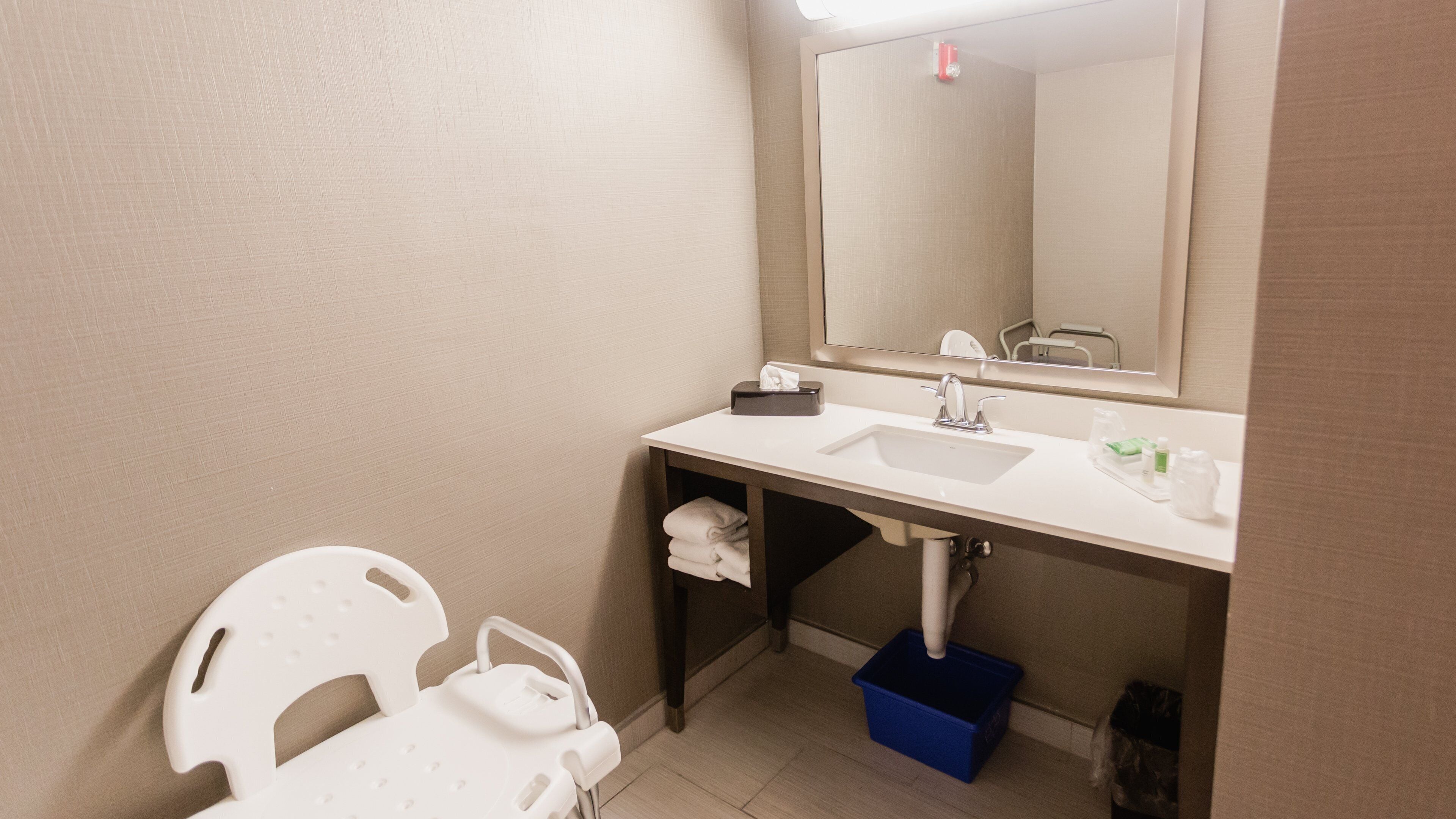 A bathroom with a white sink, mirror, and a towel rack.