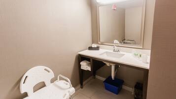 A bathroom with a white sink, mirror, and a towel rack.