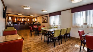 A restaurant with a wooden floor, a dining area with tables and chairs, a kitchen area with a buffet, and a bar. - Best Western Paradise Inn (Dillon)