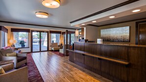A hotel lobby with a reception desk, seating area, and large windows. - Best Western Paradise Inn (Dillon)