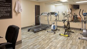 A gym with a treadmill, stationary bikes, and a mirrored wall. - Days Inn by Wyndham Harriman (Harriman)