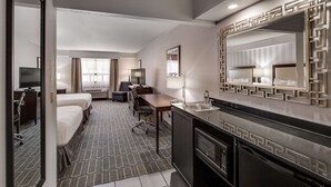A hotel room with a bed, desk, chair, and kitchenette. - Best Western Lapeer Inn (Lapeer)