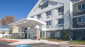 Ein Hotel der Fairfield Inn & Suites mit modernem Design, inklusive überdachter Zufahrt und Parkplatz mit barrierefreiem Zugang.