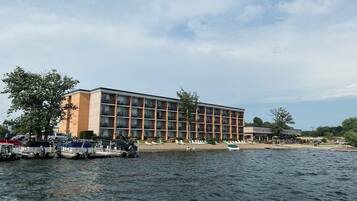 A hotel with a large building, a waterfront, and boats.
