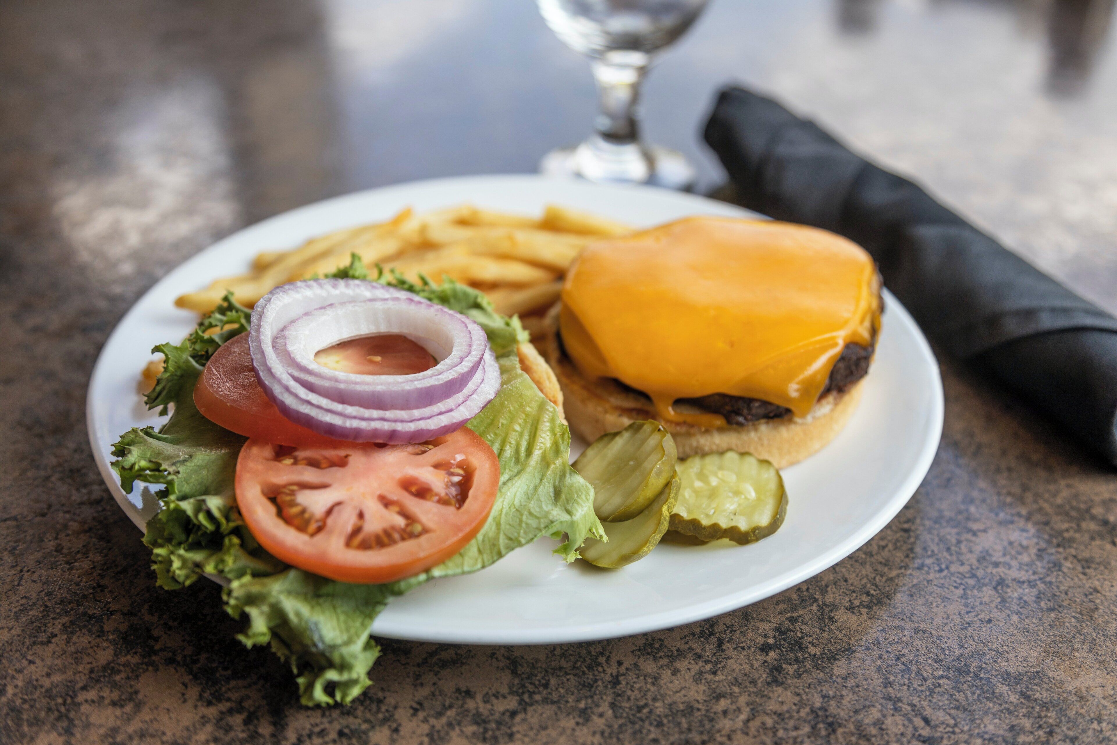 A plate with a hamburger, fries, and a salad.