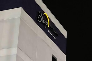 A hotel sign with the name 'Sleep' and 'INN & SUITES' indicating the type of accommodations offered.
