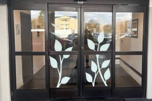 A door with a glass panel featuring a white leaf design.