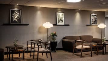 A modern waiting area with a sofa, chairs, and artwork on the walls.