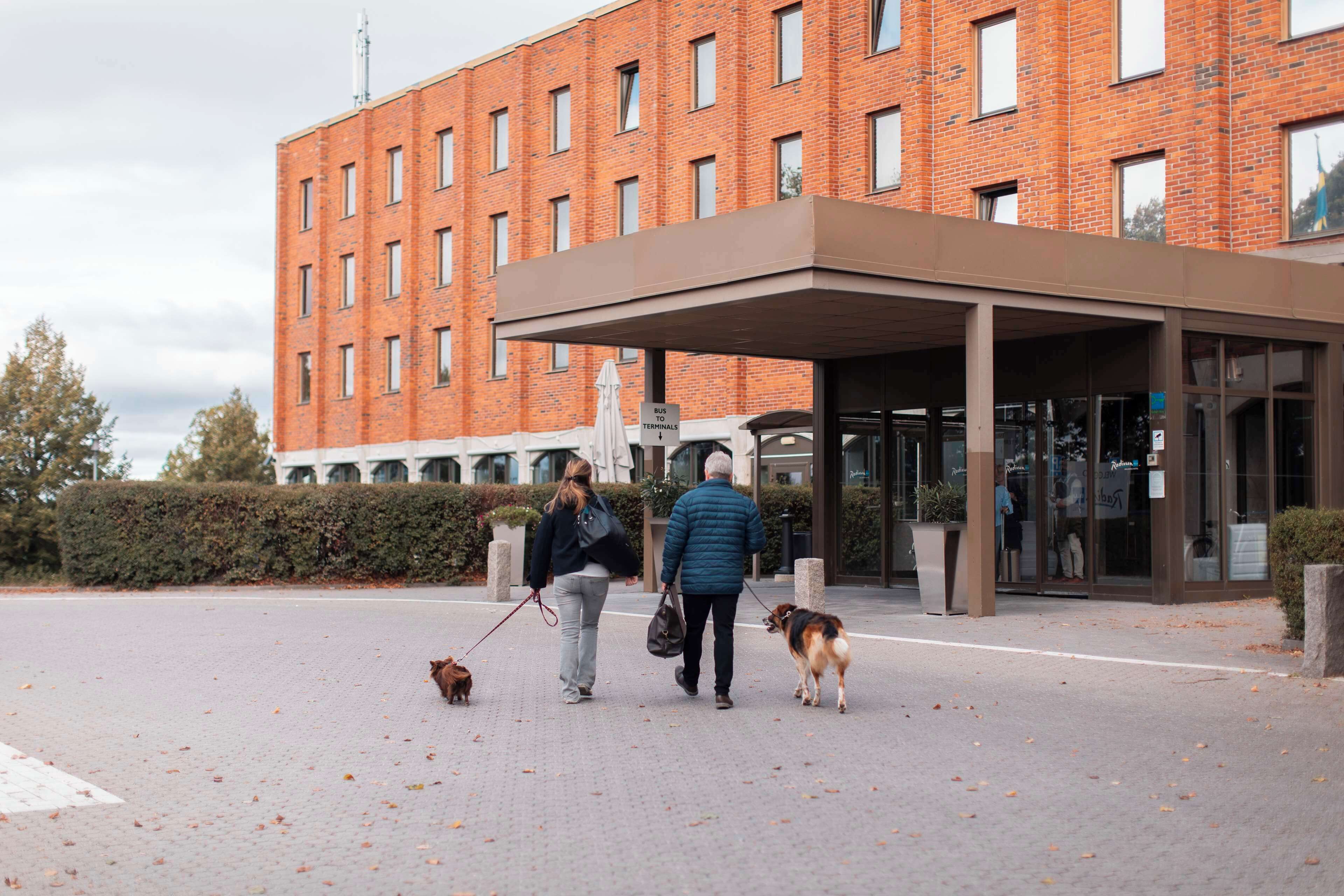 Un edificio con facciata in mattoni, ingresso coperto e un cartello che indica l'accesso al terminal degli autobus.