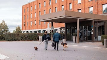 Un edificio con facciata in mattoni, ingresso coperto e un cartello che indica l'accesso al terminal degli autobus.