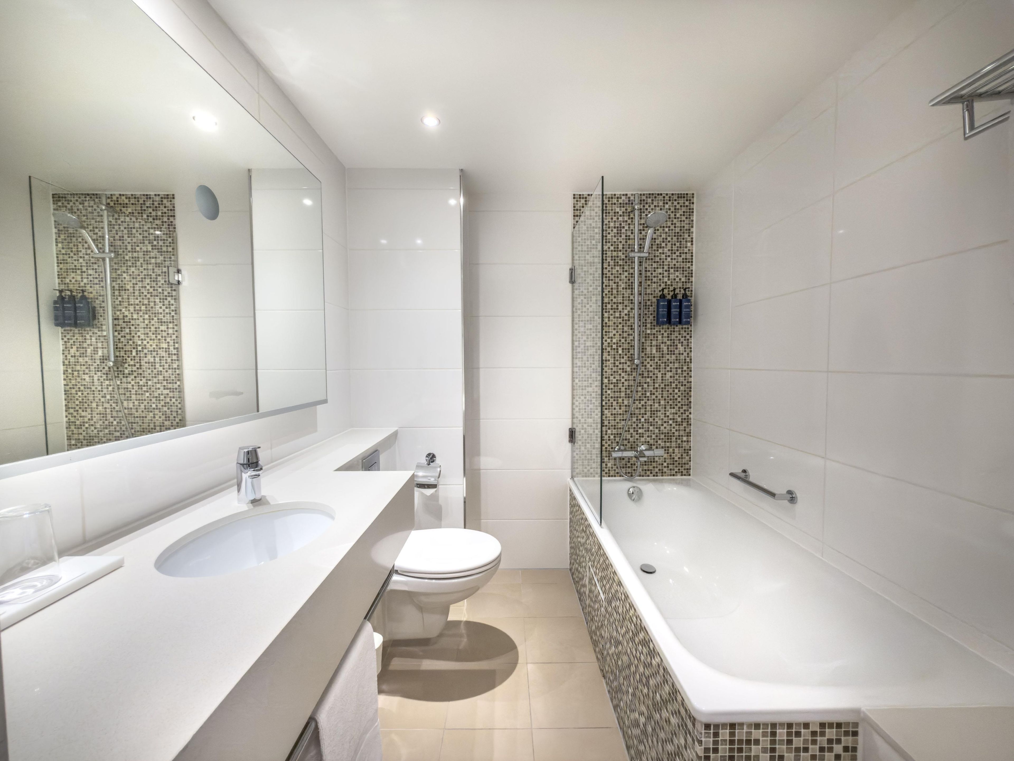 Un bagno moderno con un mobile doppio lavabo, un WC e una vasca da bagno freestanding.