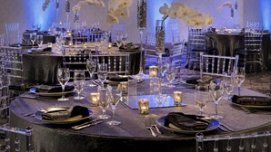 A formal dining setup with multiple tables, each set with clear glassware, plates, and cutlery. - Westchester Marriott (Tarrytown)