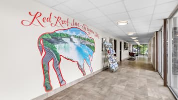 A corridor with a mural of Niagara Falls and Red Roof Inn signage.