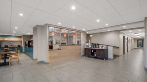 A spacious hotel lobby with a reception desk, seating area, and a coffee station. - Country Inn & Suites by Radisson, Fredericksburg South (I-95), VA (Fredericksburg)