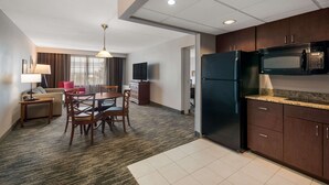 A hotel room with a kitchenette, a dining area with a table and chairs, a sofa, a TV, and a window with curtains. - Country Inn & Suites by Radisson, Fredericksburg South (I-95), VA (Fredericksburg)