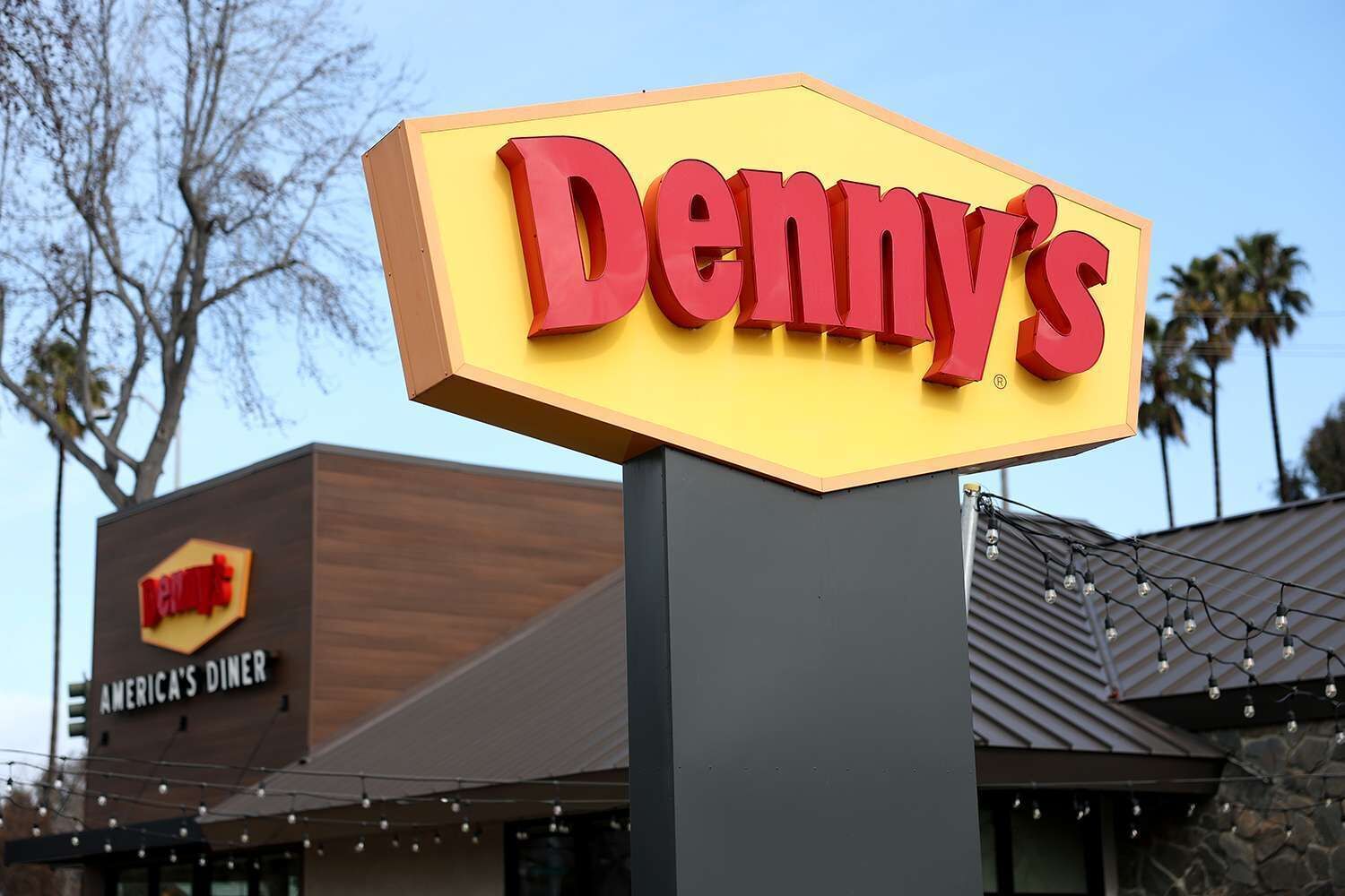 A Denny's restaurant sign with a clear view of the building's exterior.