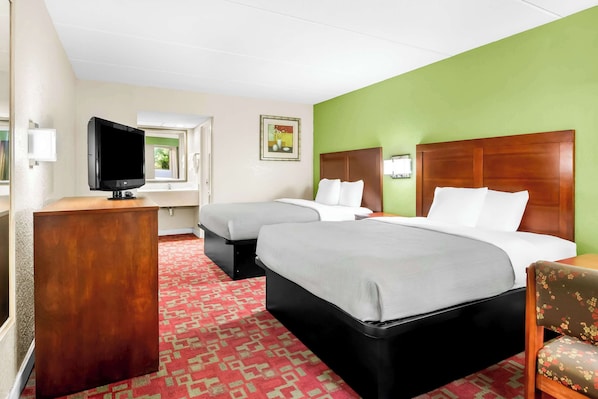 A hotel room with two beds, a TV, a desk, and a chair. - Quality Inn Selma - Smithfield (Selma)