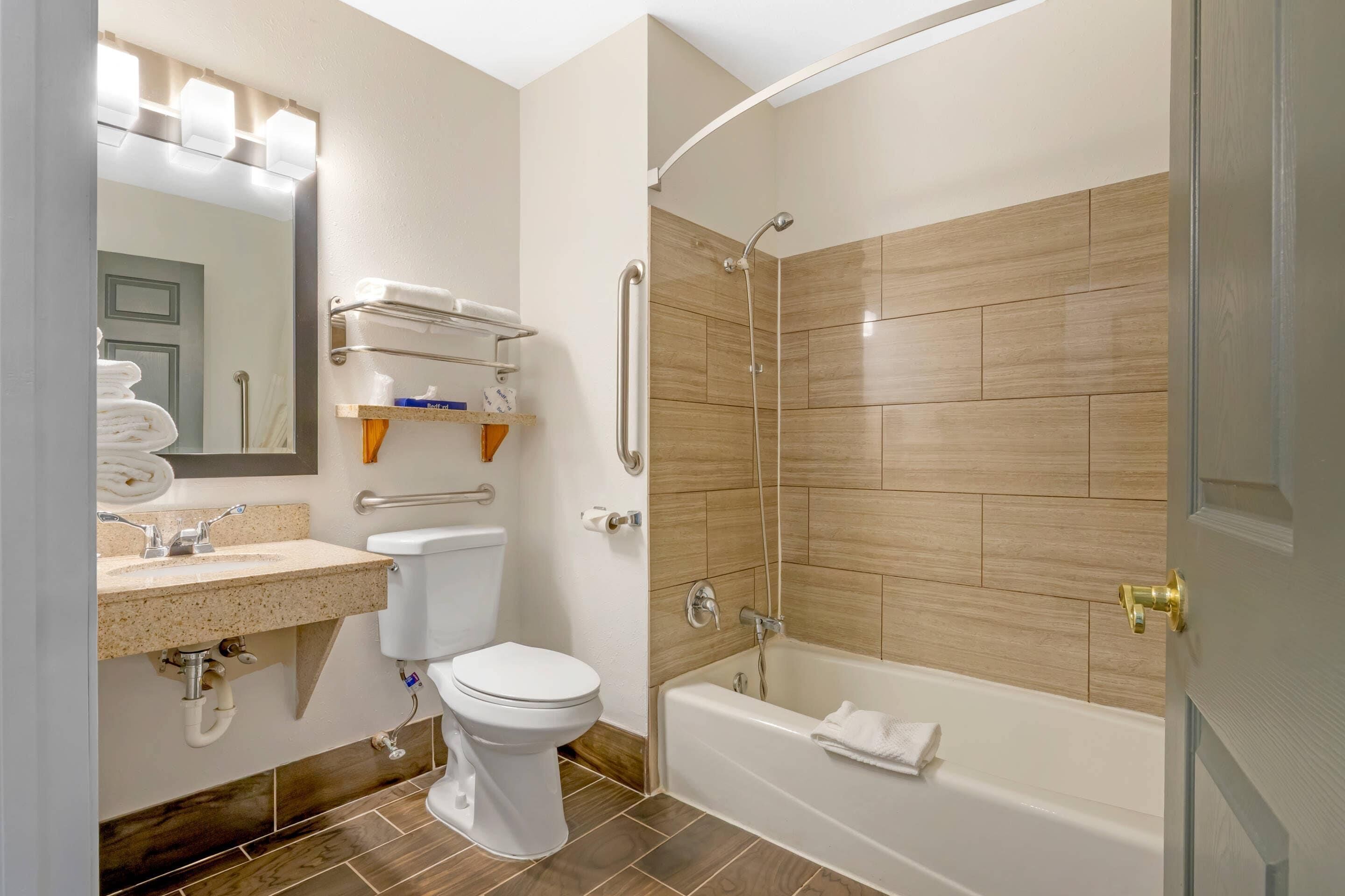 Une salle de bain moderne équipée de toilettes, d’un lavabo et d’un espace douche.
