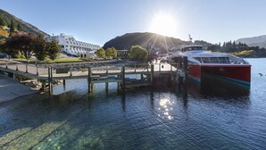 Een helder meer met een aanlegsteiger en een boot genaamd "Sail of Oregon".