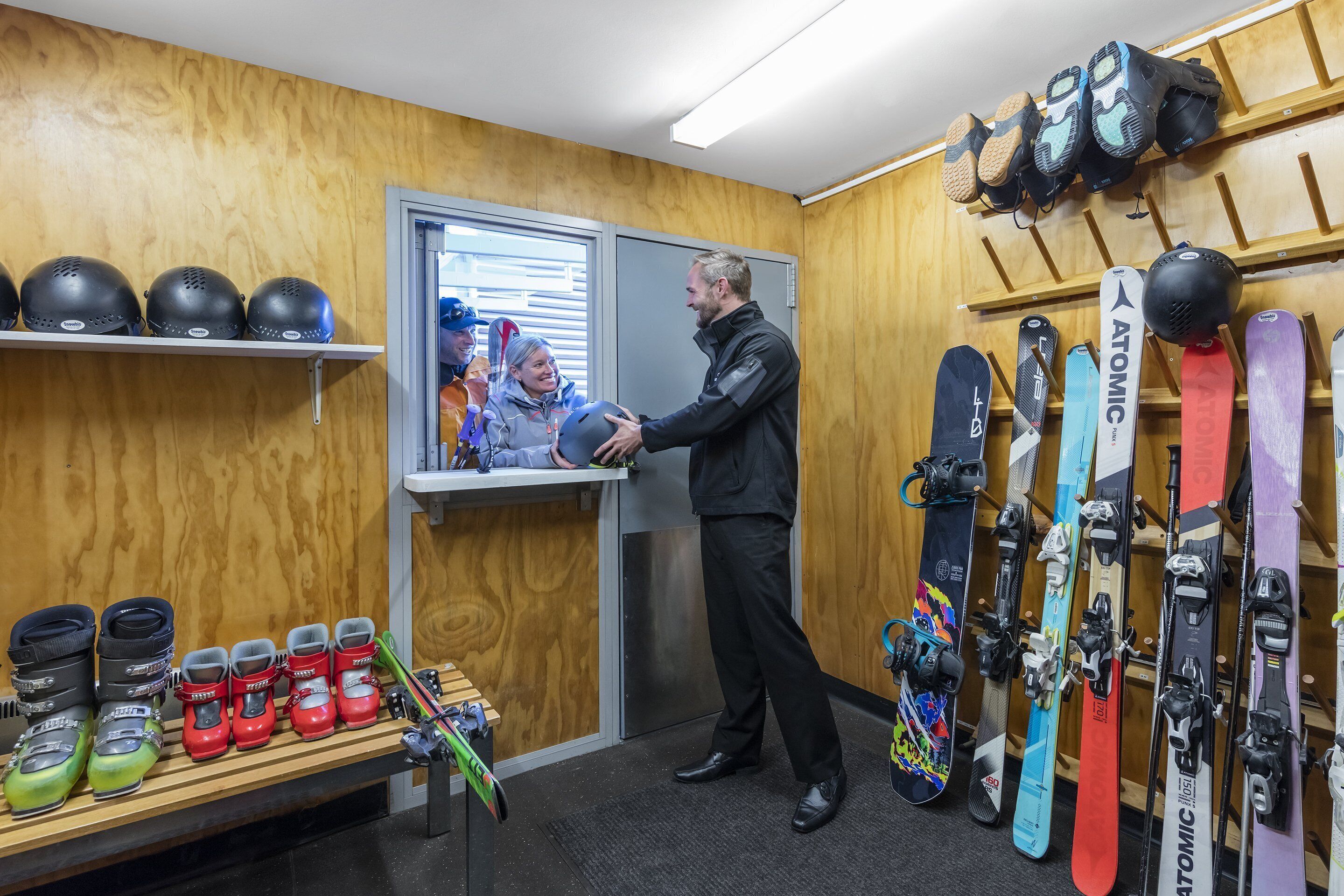 A ski equipment store with various skis and ski boots on display.