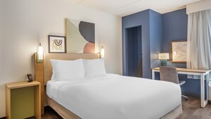A hotel room with a bed, bedside tables, a desk, and a chair. - Spark by Hilton Atlanta Airport South College Park (College Park)