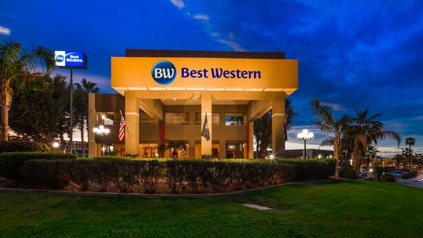 A hotel with a prominent 'Best Western' sign, a covered outdoor area, and a well-maintained lawn. - Best Western Yuma Mall Hotel & Suites (Yuma)