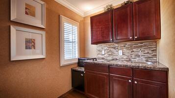 A kitchen with wooden cabinets, a tiled backsplash, and a dishwasher.