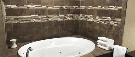 A bathroom with a freestanding bathtub, a vanity with a mirror, and a towel rack.