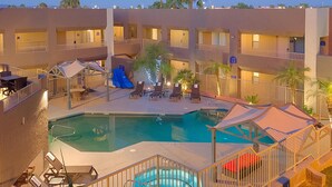 A hotel with a swimming pool, multiple balconies, and outdoor seating areas. - Best Western Yuma Mall Hotel & Suites (Yuma)