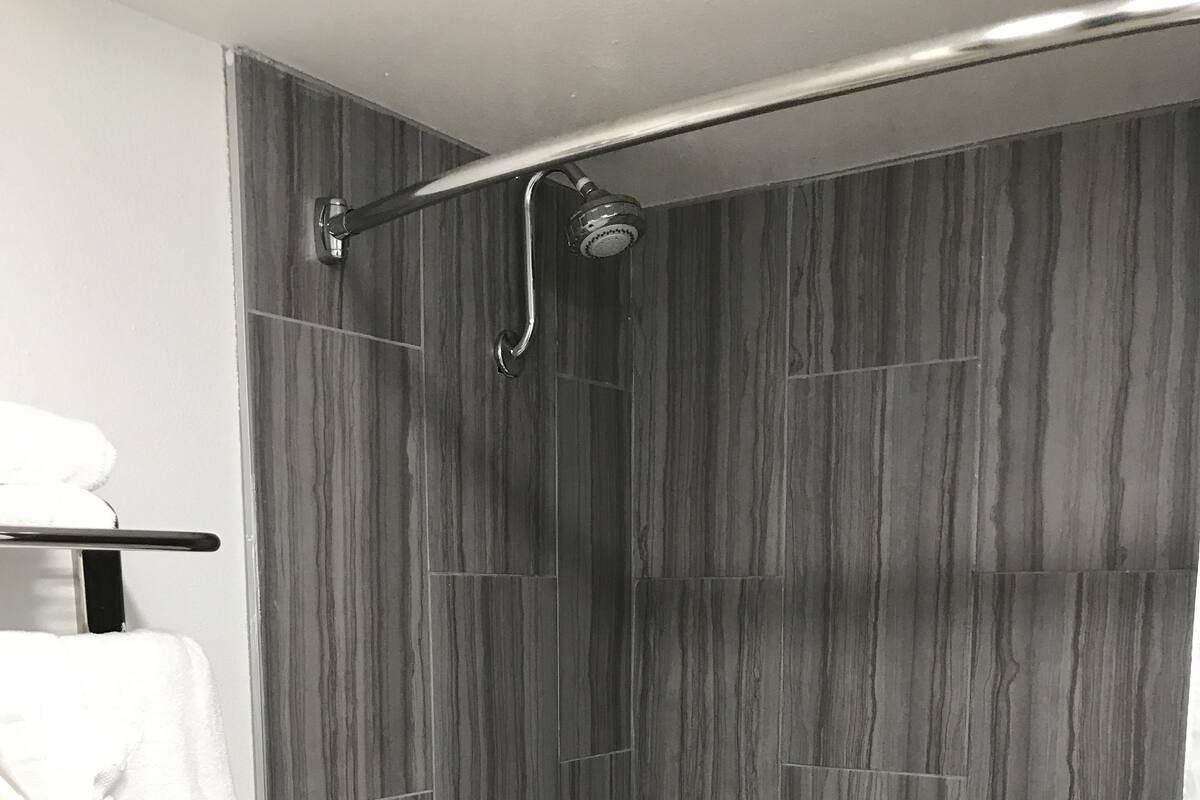 A modern bathroom with a shower, toilet, and bathtub.