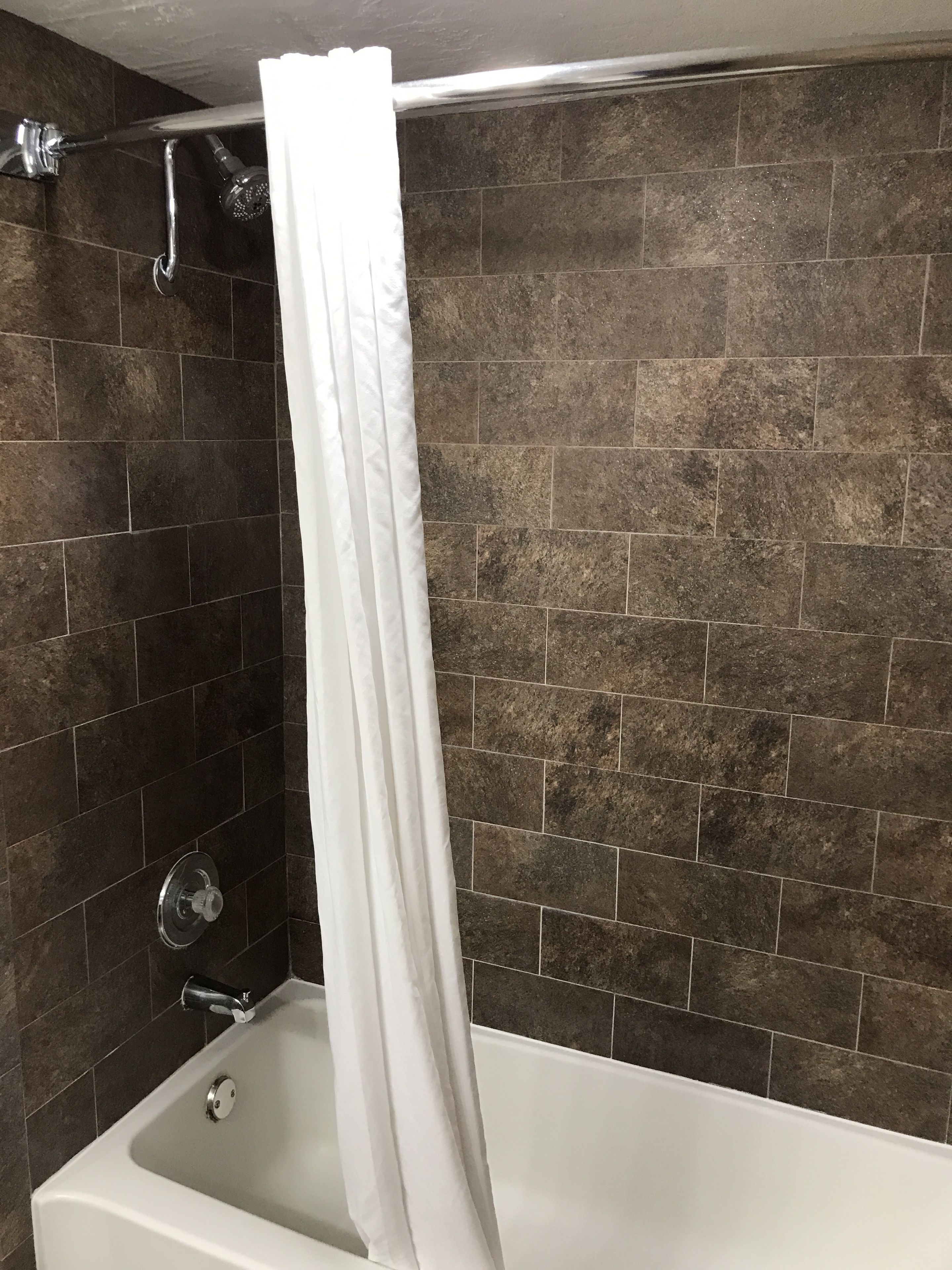 A bathroom with a bathtub, a shower, and a curtain.