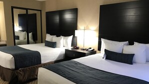 A hotel room with two beds, a nightstand, a lamp, and a mirror. - Best Western Yuma Mall Hotel & Suites (Yuma)