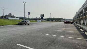 A parking lot with multiple vehicles, a Days Inn sign, and a building with a flat roof in the background.