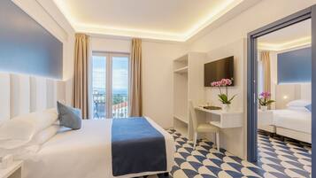 A hotel room with a bed, desk, and a large window with curtains.