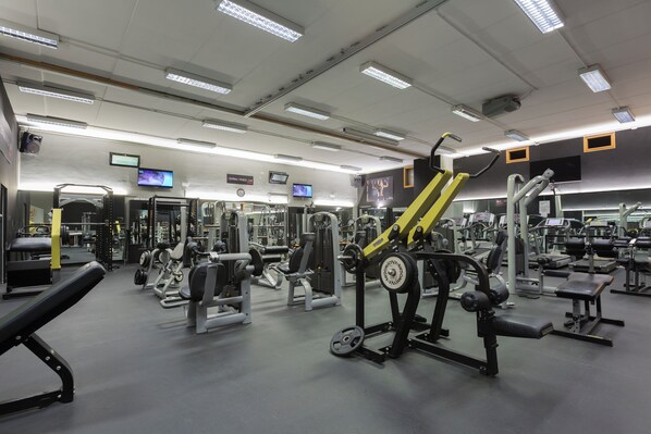 A gym with various exercise equipment, including weight machines and benches.