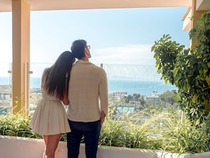 A couple standing on a balcony overlooking a cityscape with a view of the sea. - Hotel Central Wellness (Sorrento)