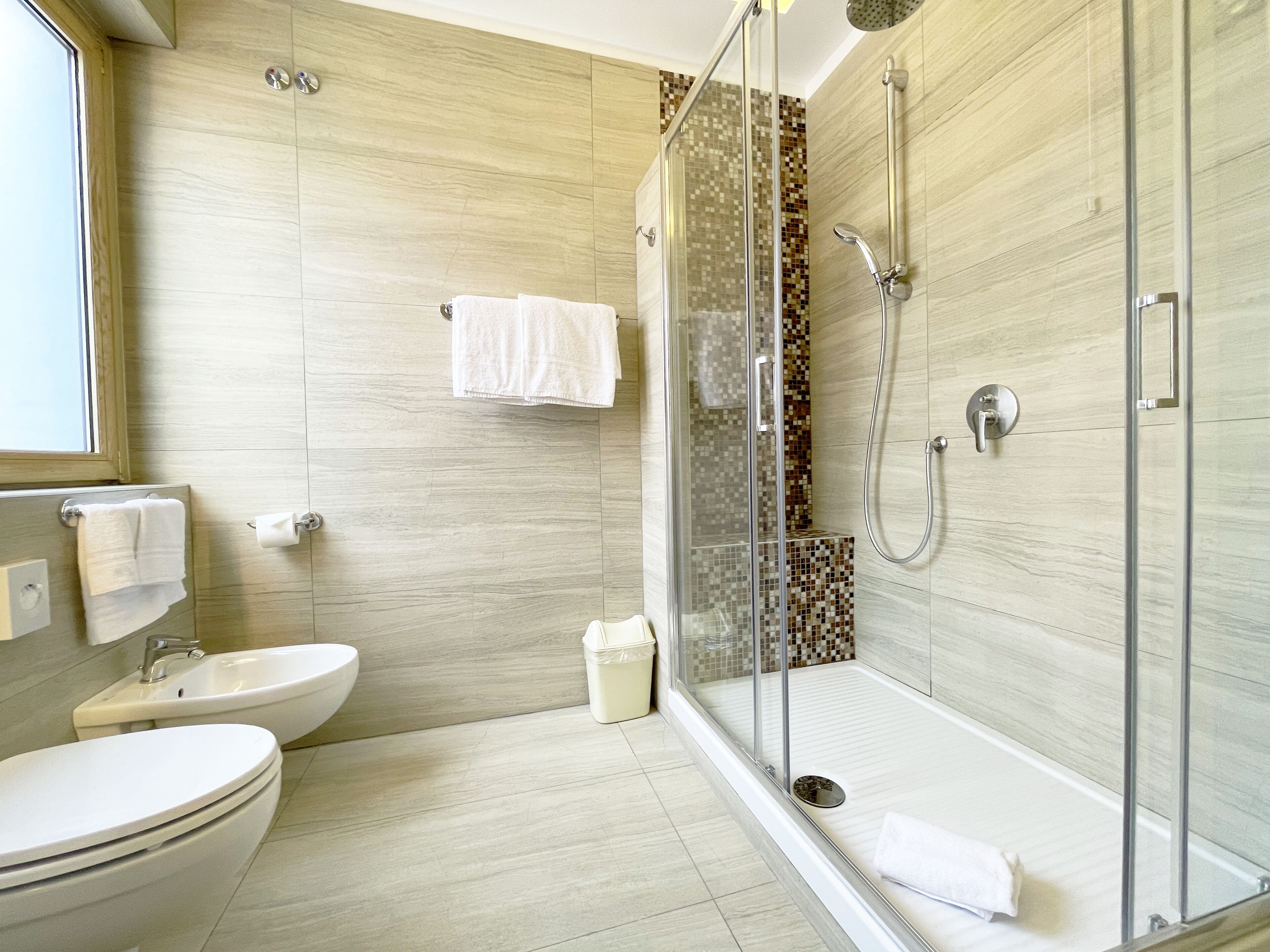 Une salle de bain moderne avec une douche à parois de verre, un lavabo et des toilettes.