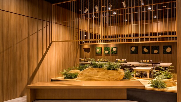 A modern interior with wooden paneling, a central seating area, and multiple tables and chairs. - Shinjuku Prince Hotel (Tokyo)