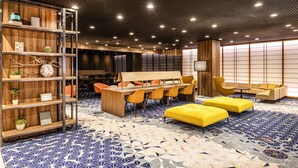 A modern hotel lobby with a wooden reception desk, seating area, and a patterned floor. - Shinjuku Prince Hotel (Tokyo)