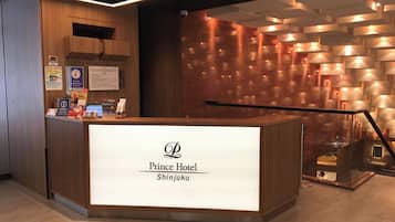 A hotel reception desk with a modern design, featuring a prominent logo and name.