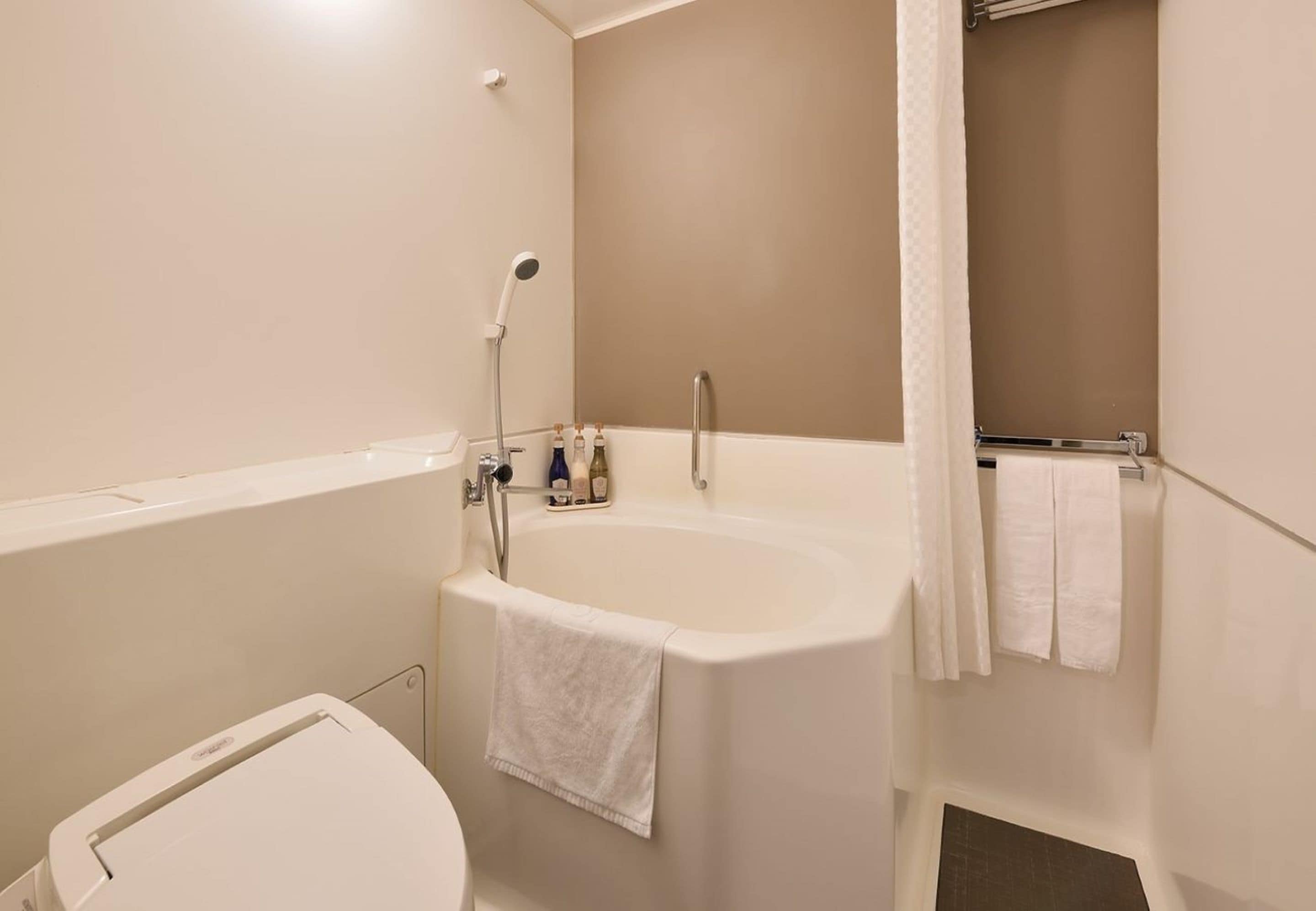 Un baño con bañera, inodoro y ducha.