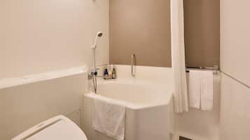 Un baño con bañera, inodoro y ducha.