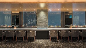 A bar area with a long counter, multiple chairs, and a city view through large windows. - Shinjuku Prince Hotel (Tokyo)
