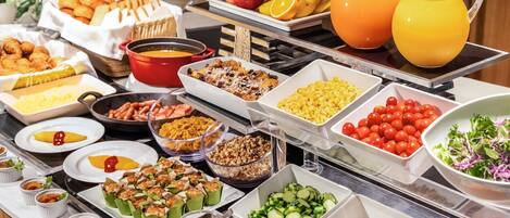 A buffet with various food items including fruits, vegetables, and prepared dishes.