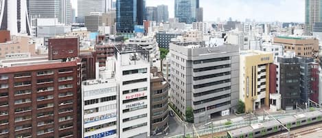 A cityscape with modern buildings, a train on tracks, and a sushi restaurant.