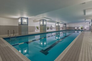 Una piscina techada, sillones reclinables de piscina