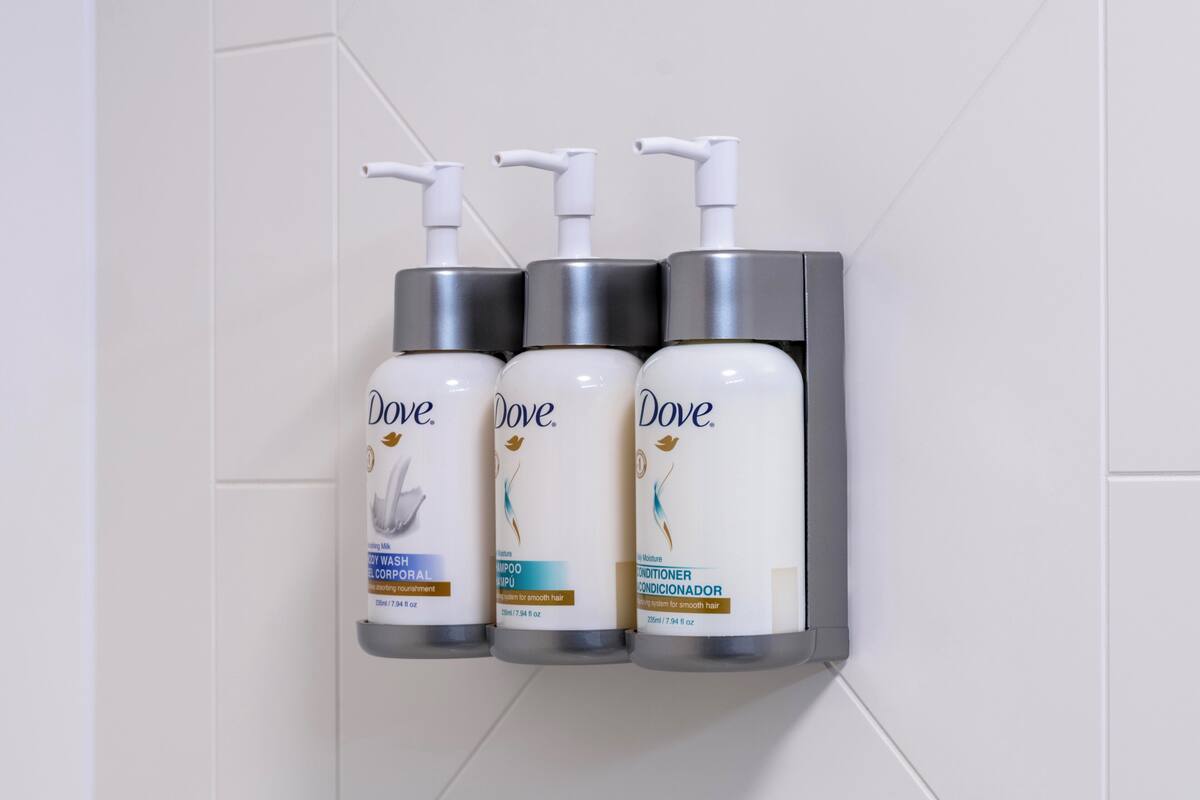 Three Dove personal care products mounted on a wall.