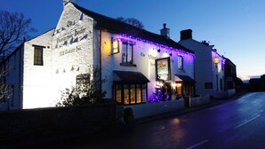 A traditional white building with a sign reading "The Wensleydale Inn." - The Wensleydale Heifer (Leyburn)